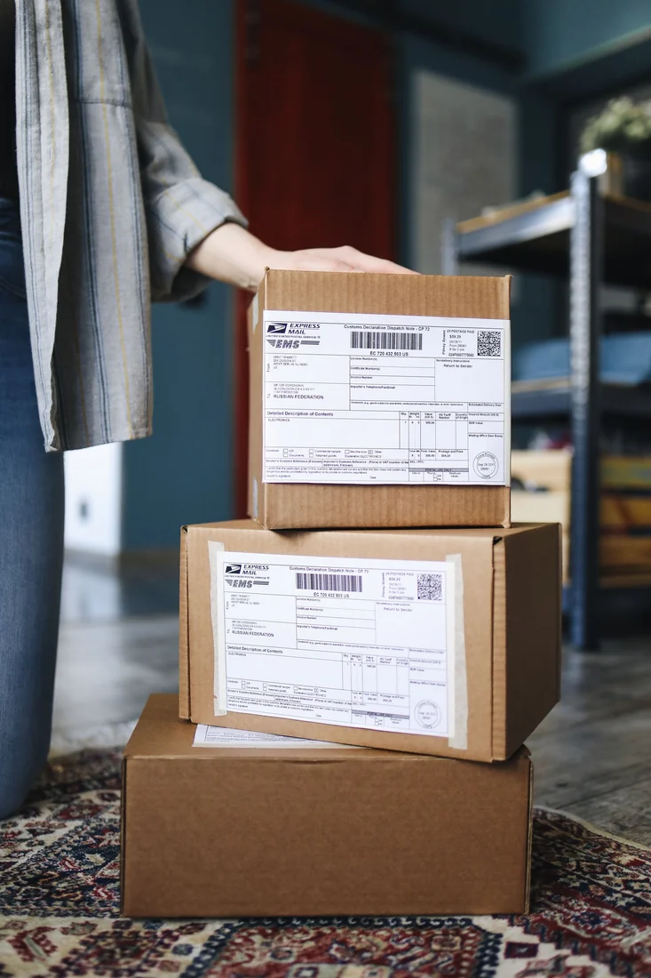 Shipping labels with barcodes attached to stacked cardboard parcels