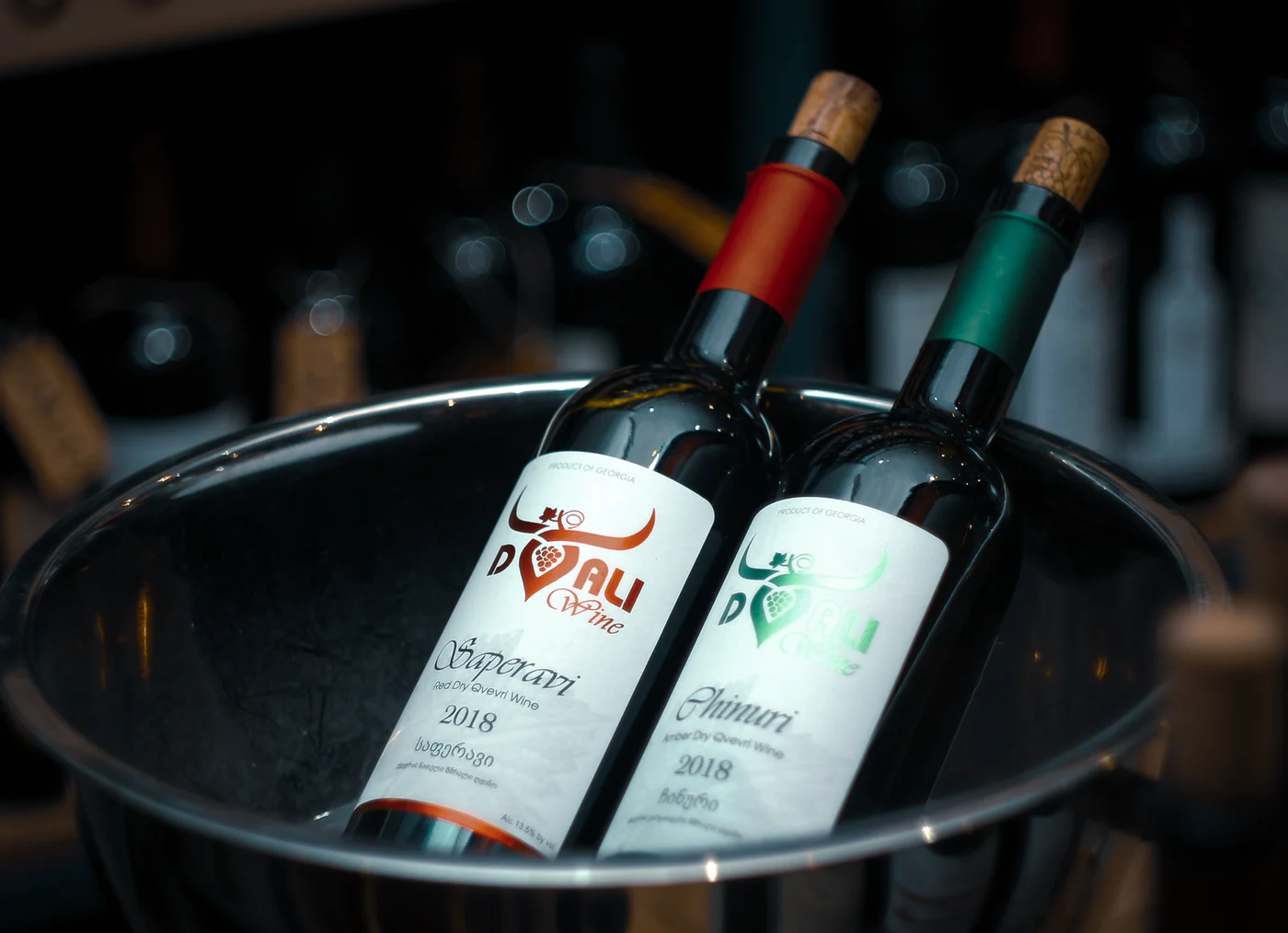 Labelled glass wine bottles standing in an ice bucket